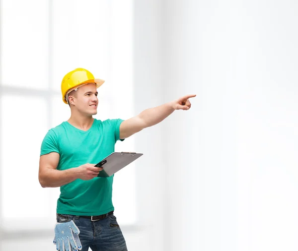 Lächelnder Mann mit Helm und Klemmbrett — Stockfoto