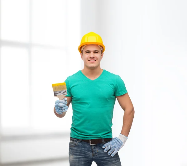 Lächelnder Handwerker im Helm mit Pinsel — Stockfoto