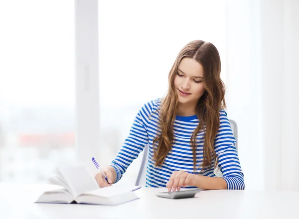 Étudiante avec livre, calculatrice et cahier — Photo