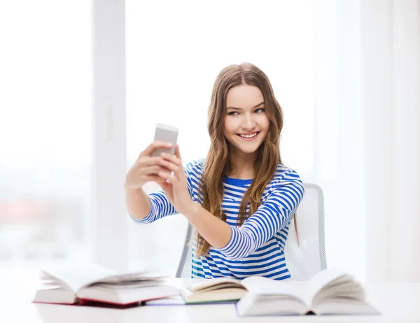 Usměvavá studentka s smartphone a knihy — Stock fotografie