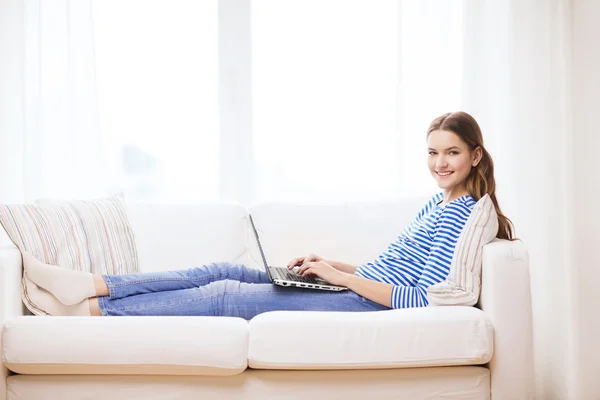 Sorrindo adolescente com computador portátil em casa — Fotografia de Stock