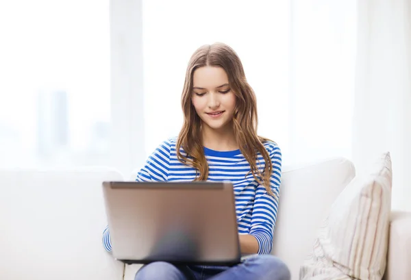 Smiling teenage girl with laptop computer at home — Stock Photo, Image