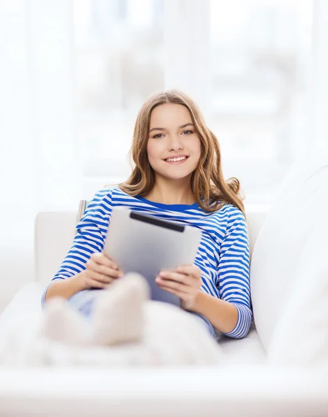 Lachende tienermeisje met tablet pc thuis — Stockfoto