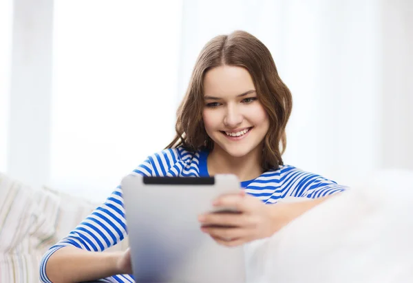 Lachende tienermeisje met tablet pc thuis — Stockfoto