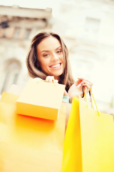 Femme avec des sacs à provisions en ville — Photo