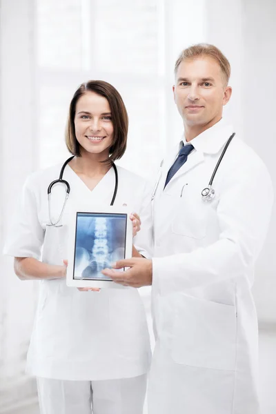 Dois médicos mostrando raio-x no tablet pc — Fotografia de Stock