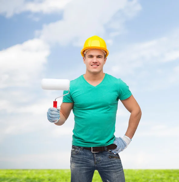 Operaio manuale sorridente in casco con rullo di vernice — Foto Stock