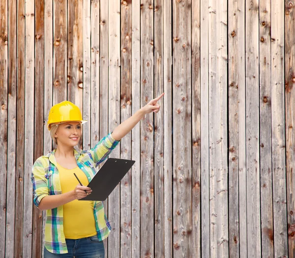 Donna sorridente in casco con appunti — Foto Stock