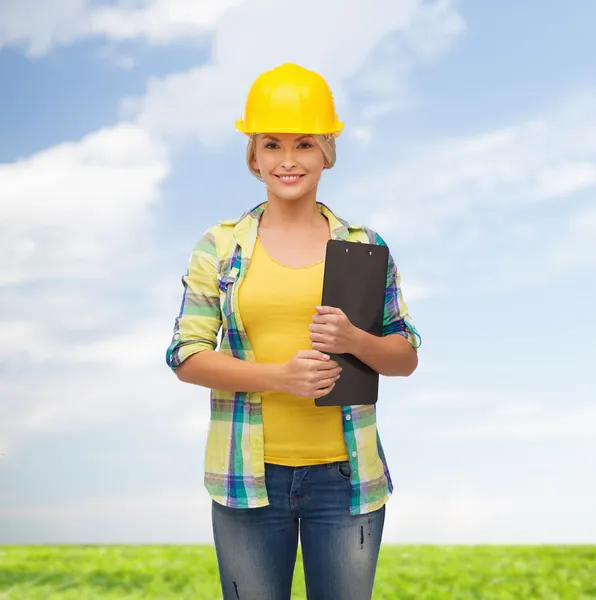 Mujer sonriente en casco con portapapeles — Foto de Stock