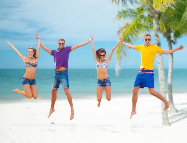 Gruppo di amici o coppie che saltano sulla spiaggia — Foto Stock