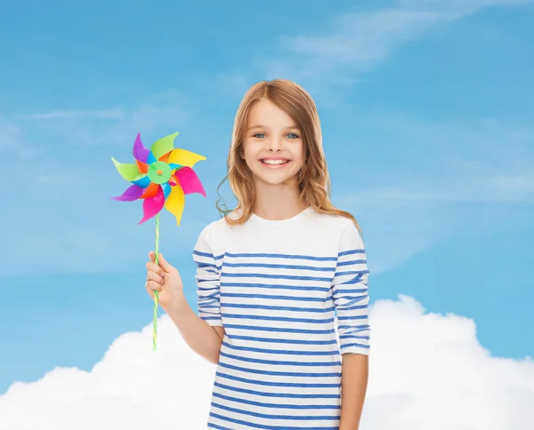 Criança sorridente com brinquedo colorido de moinho de vento — Fotografia de Stock