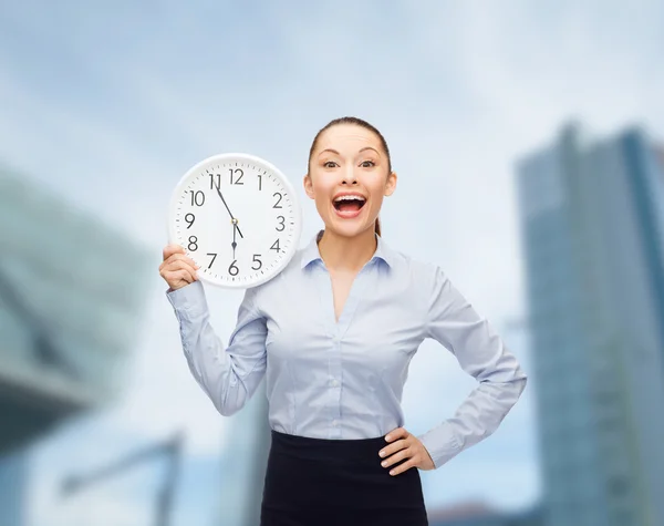 Attractive businesswoman with wall clock — Stock Photo, Image