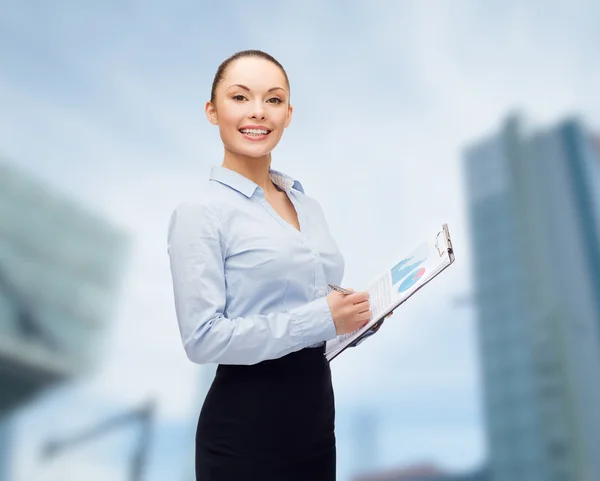 Joven mujer de negocios sonriente con portapapeles y pluma — Foto de Stock