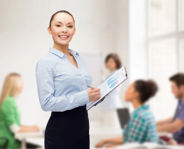 Junge lächelnde Lehrerin mit Klemmbrett und Stift — Stockfoto