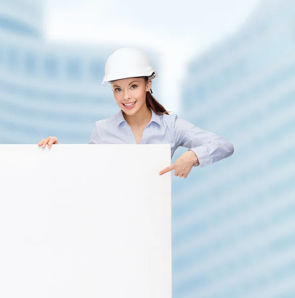 Businesswoman in helmet pointing finger to board — Stock Photo, Image