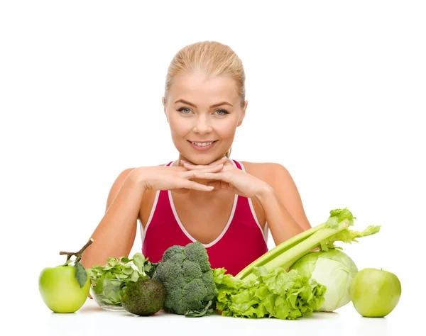 Sorrindo mulher desportiva com alimentos orgânicos — Fotografia de Stock