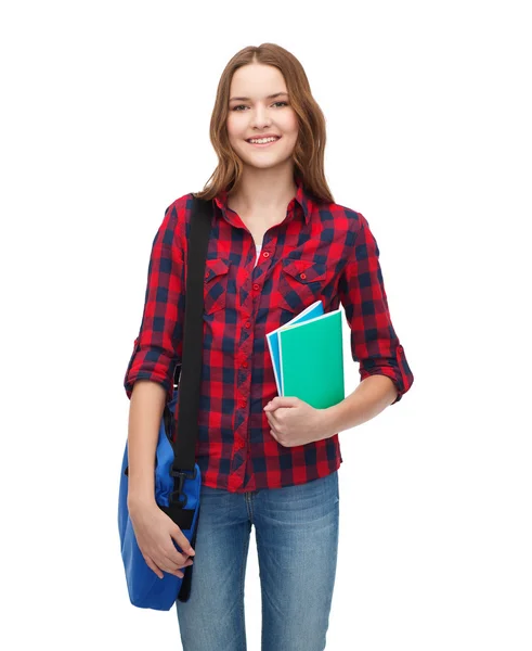 Lächelnde Studentin mit Tasche und Notizbüchern — Stockfoto