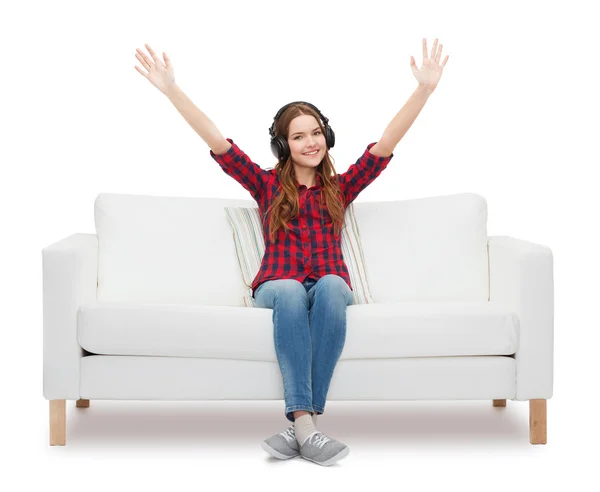 Teenager-Mädchen sitzt mit Kopfhörern auf Sofa — Stockfoto