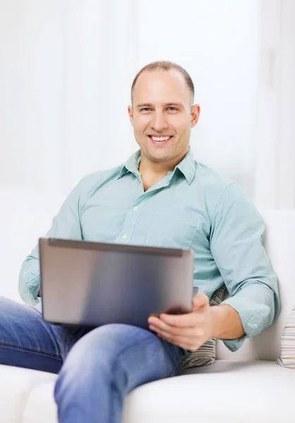 Homme souriant travaillant avec un ordinateur portable à la maison — Photo