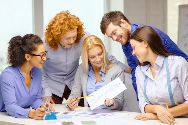 Sonriente equipo creativo mirando bosquejo — Foto de Stock