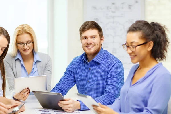 Equipe sorrindo com pc mesa e papéis de trabalho — Fotografia de Stock