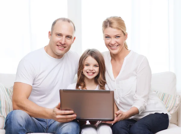 Föräldrar och liten flicka med laptop hemma — Stockfoto