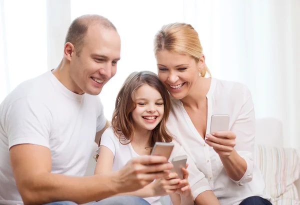 Parents et petite fille avec smartphones à la maison — Photo