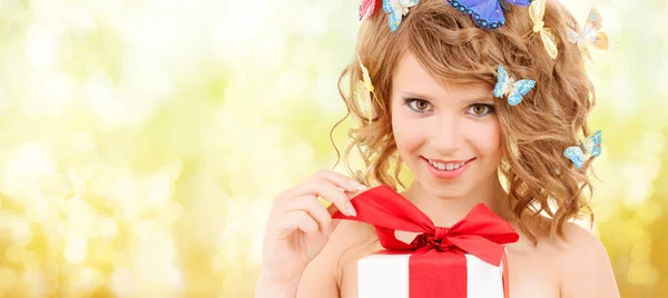 Adolescente con mariposas en el pelo regalo de apertura — Foto de Stock