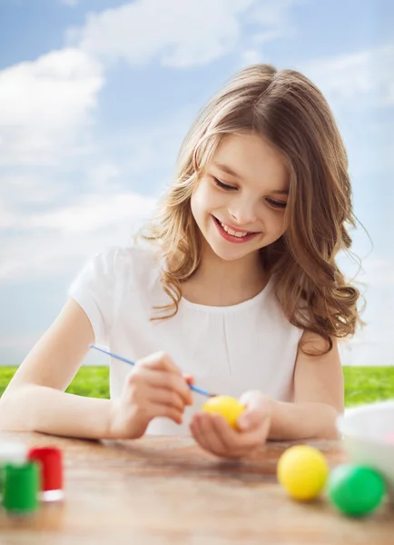 Uśmiechnięta dziewczyna trochę barwienia jaj na Wielkanoc — Zdjęcie stockowe