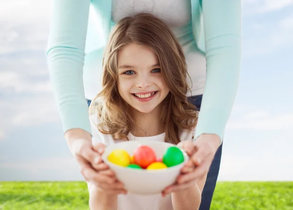 微笑の女の子と着色された卵を抱いて踊る母親 — ストック写真