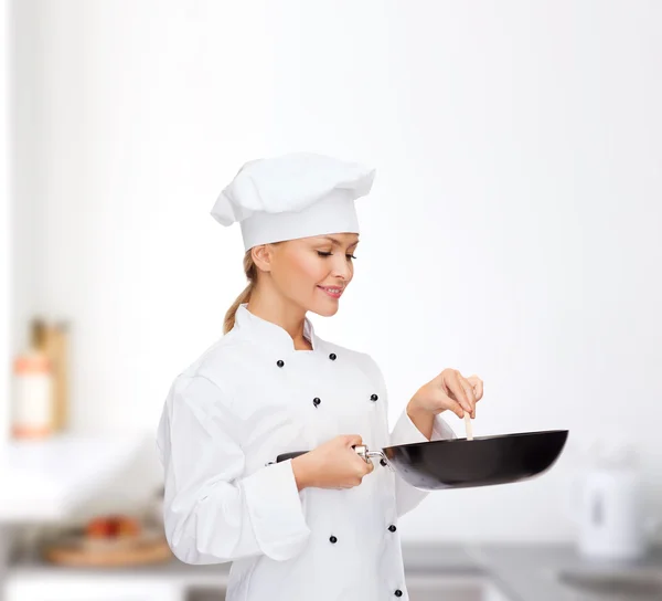 Smiling female chef with pan and spoon — Stock Photo, Image