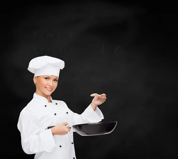Chef sonriente con sartén y cuchara —  Fotos de Stock