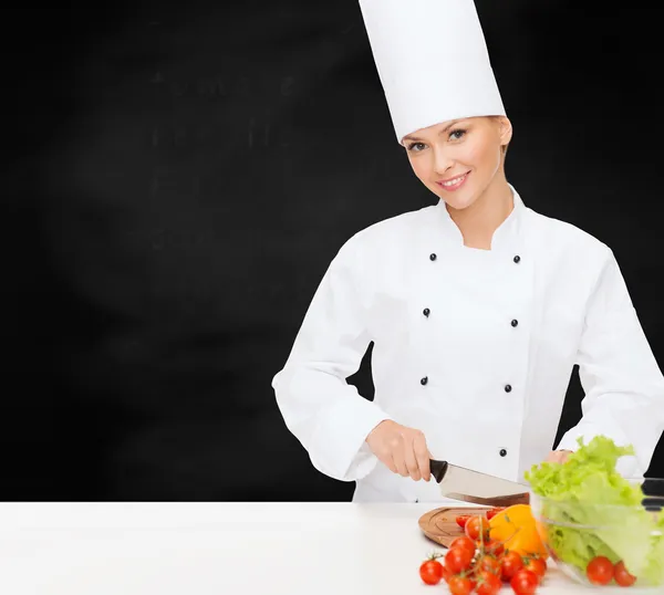 Glimlachend vrouwelijke chef-kok hakken vagetables — Stockfoto
