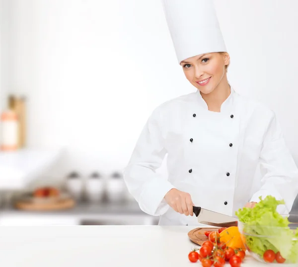 Glimlachend vrouwelijke chef-kok hakken vagetables — Stockfoto