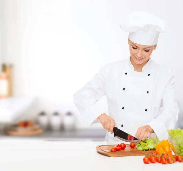 Glimlachend vrouwelijke chef-kok hakken vagetables — Stockfoto