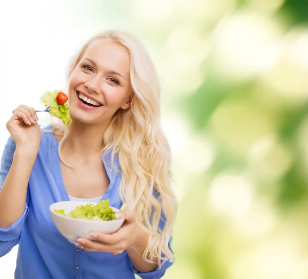 Jovem sorridente com salada verde — Fotografia de Stock