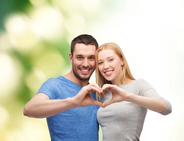 Smiling couple showing heart with hands — Stock Photo, Image