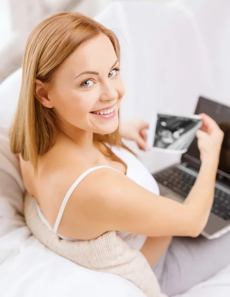 Smiling pregnant woman with laptop computer — Stock Photo, Image