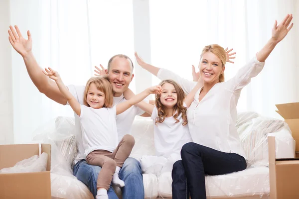 Lachende ouders en twee kleine meisjes in het nieuwe huis — Stockfoto