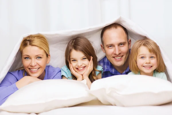 Happy family with two kids under blanket at home — Stock Photo, Image