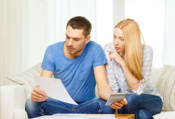 Druk koppel met papieren en rekenmachine thuis — Stockfoto