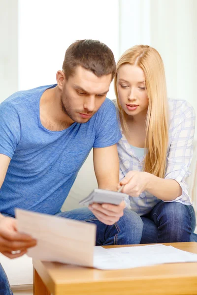 Couple occupé avec papiers et calculatrice à la maison — Photo