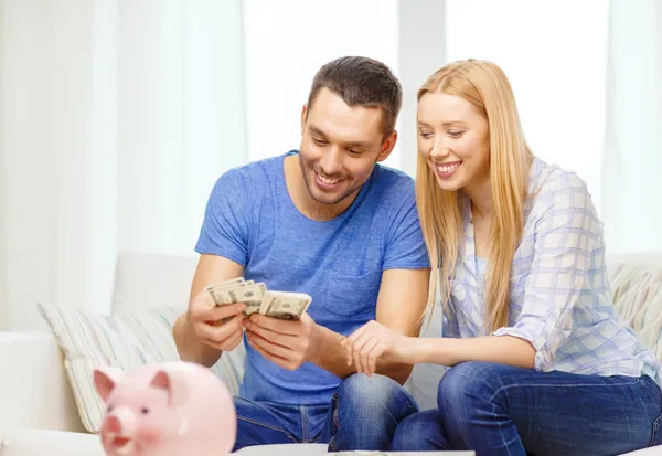 Sorrindo casal contando dinheiro em casa — Fotografia de Stock