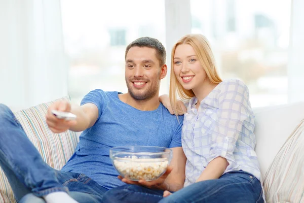 Glimlachend paar met popcorn kijken naar film thuis — Stockfoto