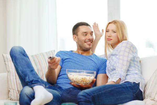 Lachende paar met popcorn kiezen wat om naar te kijken — Stockfoto