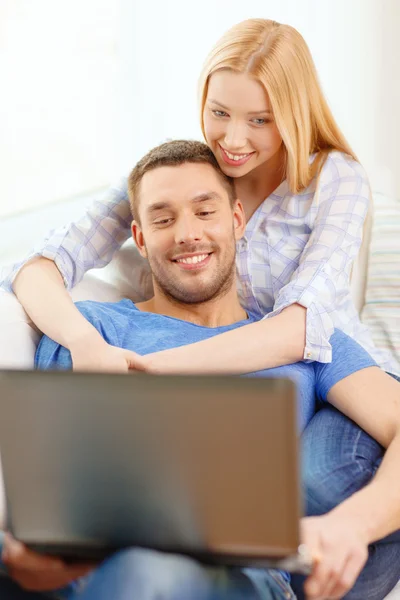 Smiling happy couple with laptop at home — Stock Photo, Image