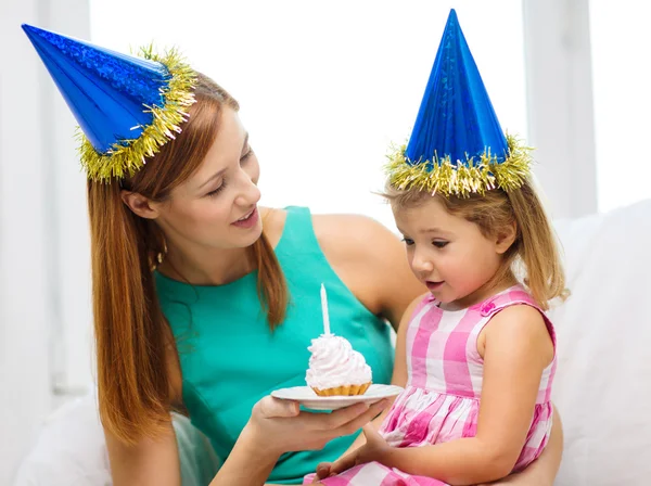 Mother and daughter in blue hats with cake — Stock Photo, Image