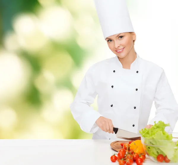 Sorrindo chef feminino cortando vagetáveis — Fotografia de Stock