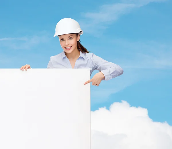 Businesswoman in helmet pointing finger to board — Stock Photo, Image