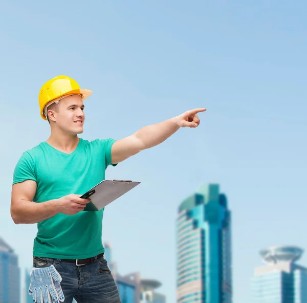 Hombre sonriente en casco con portapapeles — Foto de Stock